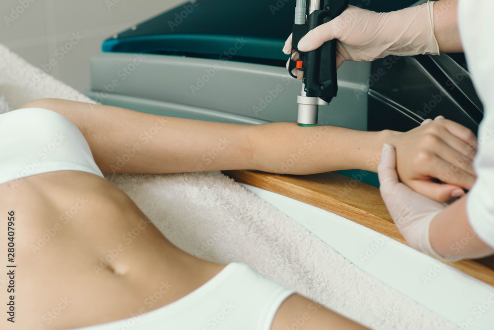 Fototapeta premium beautician removes hair on beautiful female hands using a laser. hair removal on the hands, laser procedure at clinic
