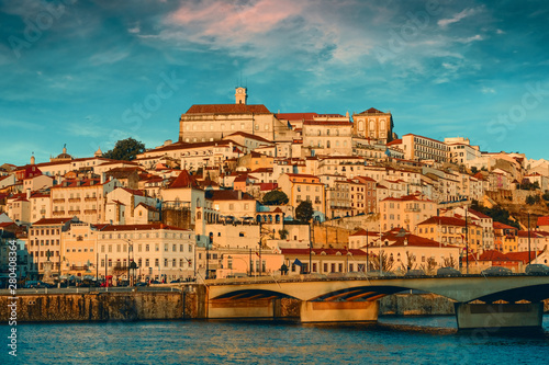 cityscape of the University City of Coimbra in Portugal. Evening panorama at sunset, with a bridge over the river Mondega