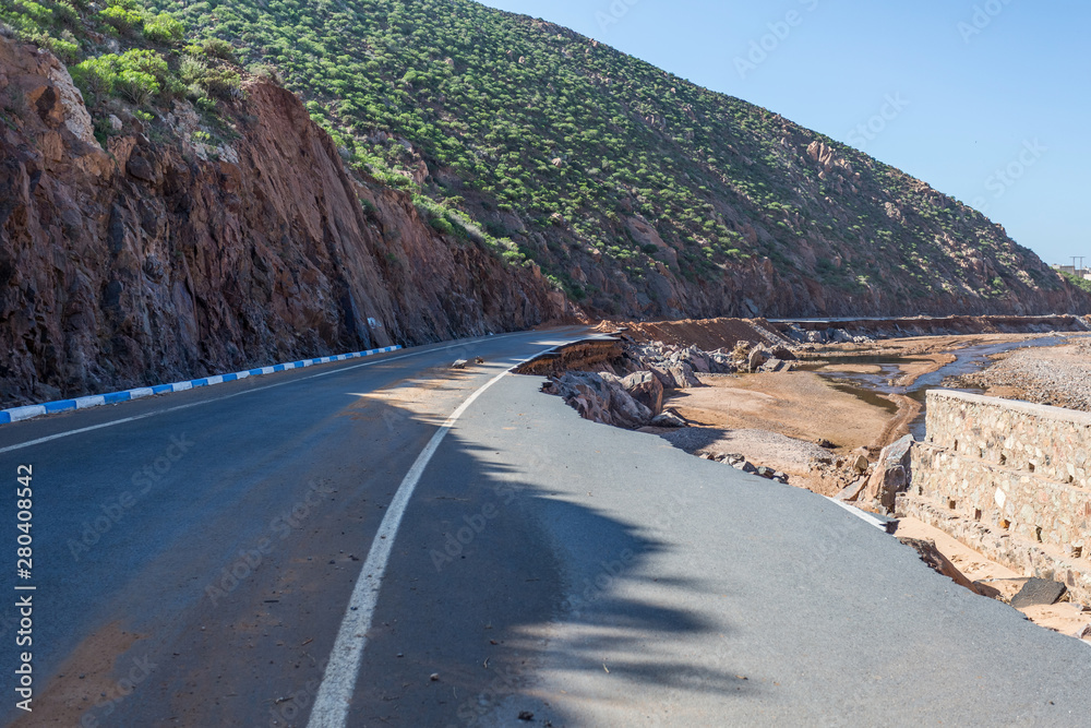 Destroyed asphalt road in the mountains as a result of a landslide, river spill
