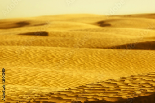 Golden sand dunes and barkhans in the desert photo