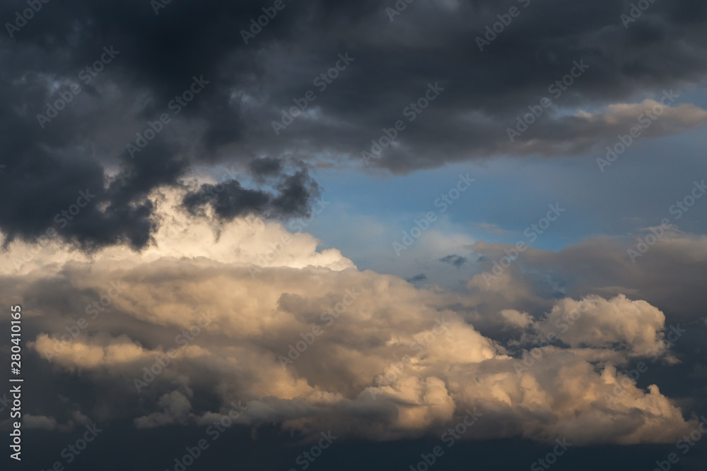 Dramatic big white fluffy storm cumulus clouds in blue sky 