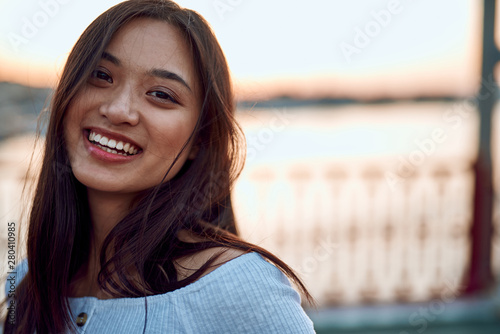 Charming asian lady on bridge in sunset light