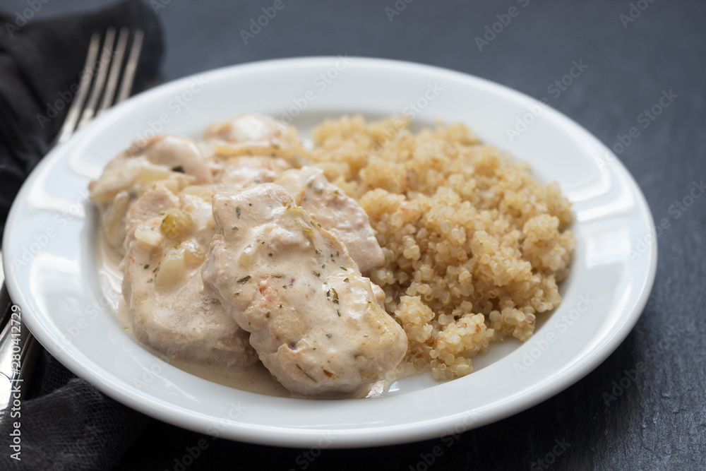 dish of meat with sauce and boiled quinoa on white wooden background