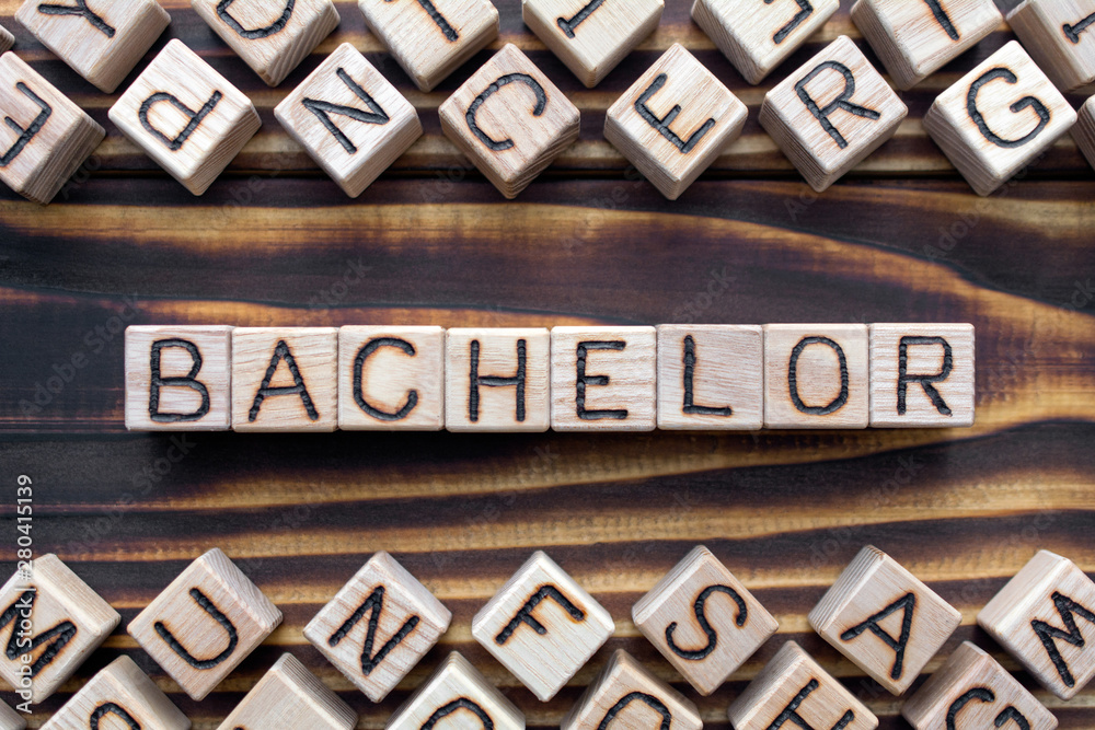 bachelor - word from wooden blocks with letters, *** concept, random letters around, top view on wooden background bachelor - word from wooden blocks with letters, *** concept, random letters around, top view on wooden background