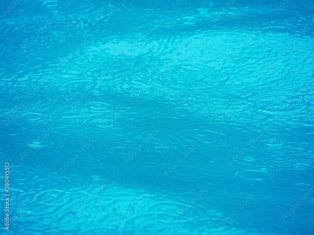 the surface of swimming pool and water expanding ripple effect background.