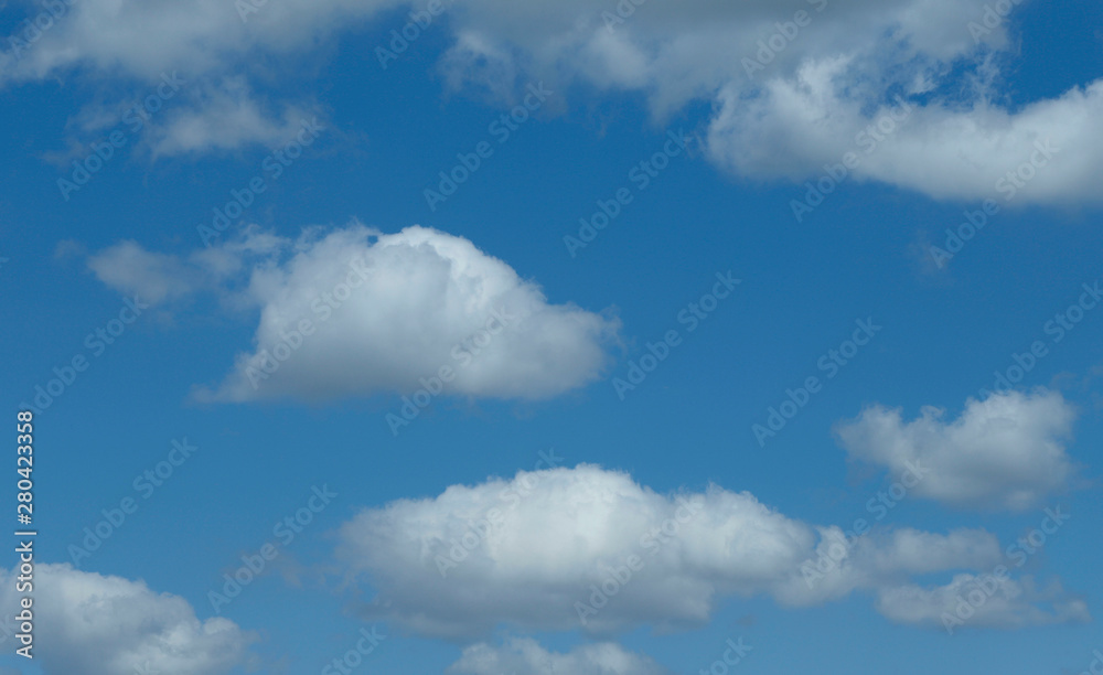 Blue sky background with white clouds. Cropped shot, horizontal, free space. Concept of natural beauty. Blue sky background with white clouds. Cropped shot, horizontal, free space. Concept of natural beauty.