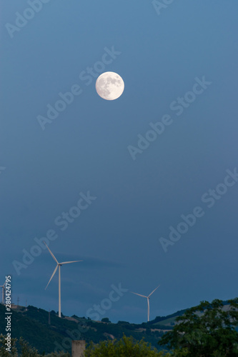 wind turbines at night on the hill in a full moon night photo