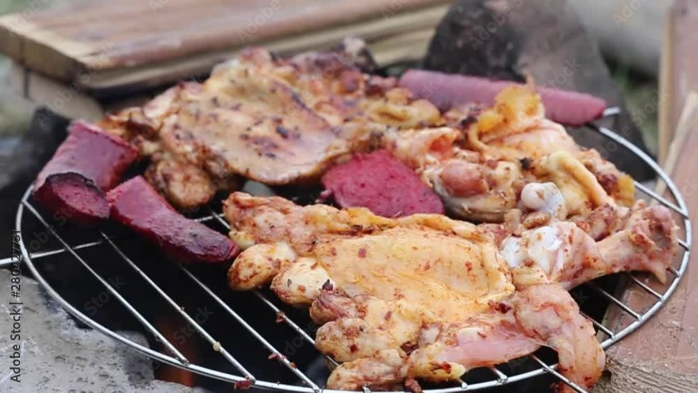 sausage and chicken cooking on a barbecue sausage and chicken cooking on a barbecue
