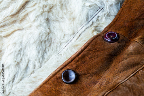 small brown thick seude jacket with white sheep fur lining closeup texture with selective focus and blur photo