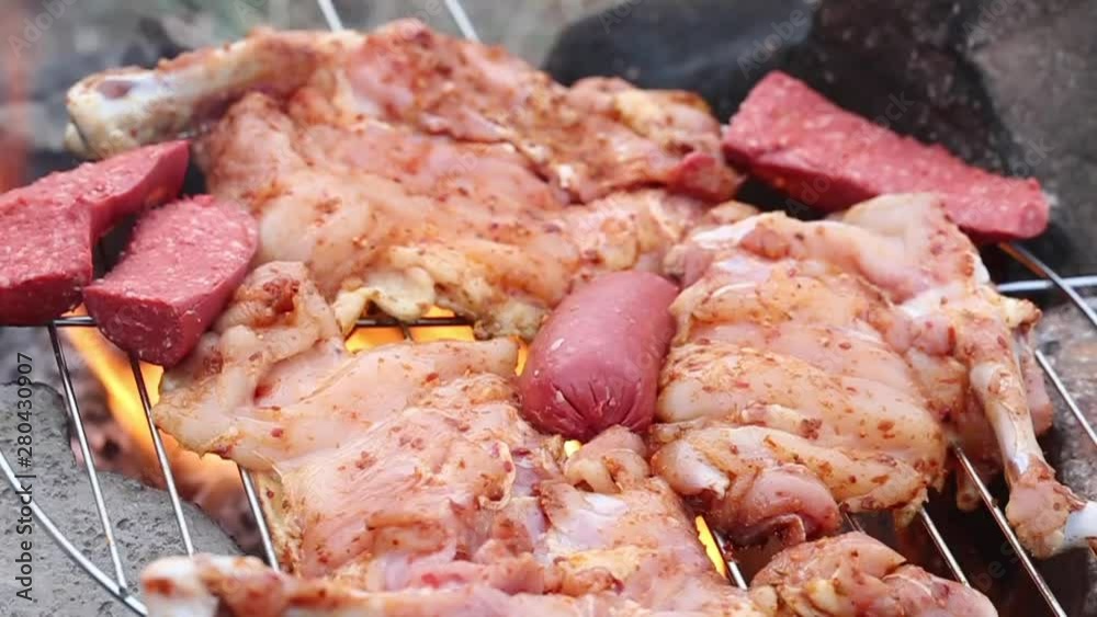 sausage and chicken cooking on a barbecue sausage and chicken cooking on a barbecue