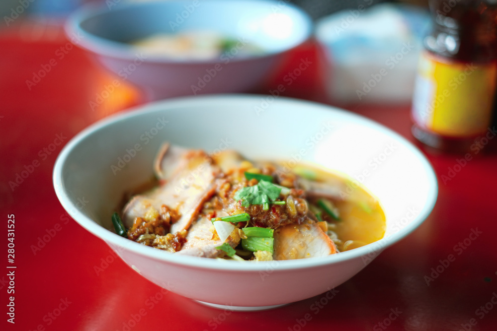 Close up hot noodles and sour soup ( tomyam ) on red dining table Close up hot noodles and sour soup ( tomyam ) on red dining table