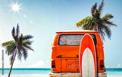 A red orange vintage van in the ocean and sunny beach view. Summer time and fun on the beach. photo