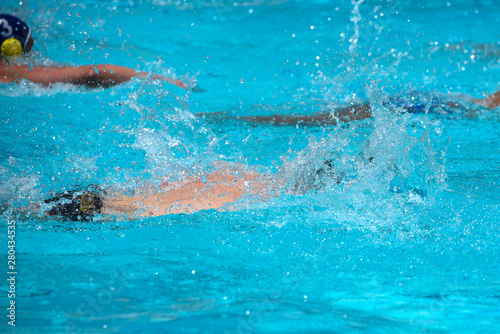Athletes swimming freestyle on a swimming pool © Michalis Palis