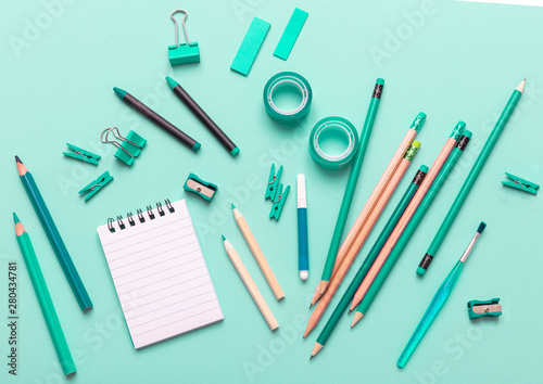 Flat lay of office, school stationery on green background