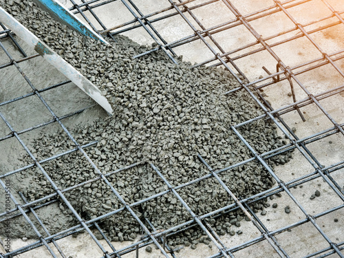 Pouring ready-mixed concrete after placing steel reinforcement to make the road by mixing mobile the concrete mixer in construction site