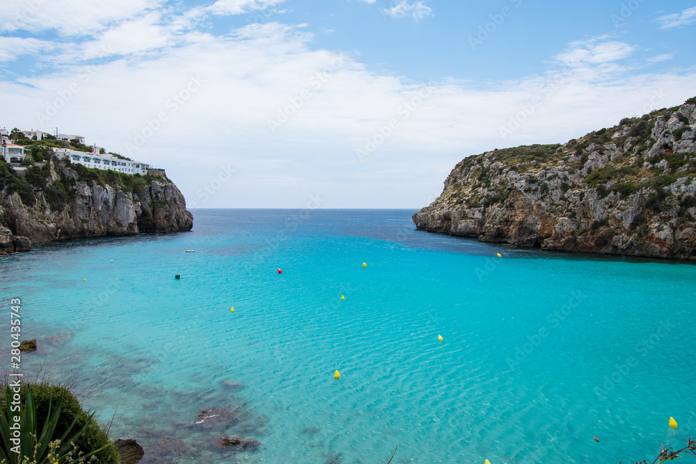 Turquoise water and beautiful sandy beach at Cala en Porter, Menorca.