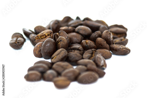 Closeup of roasted black coffee beans on white background
