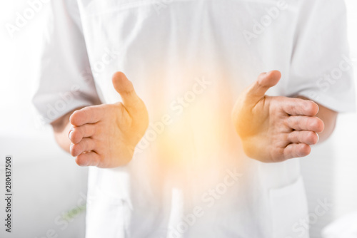 Fotografie cropped view of healer cleaning aura on white