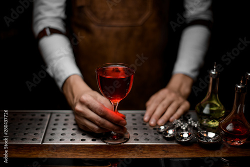 Close-up of bartender with glass of cocktail on counter