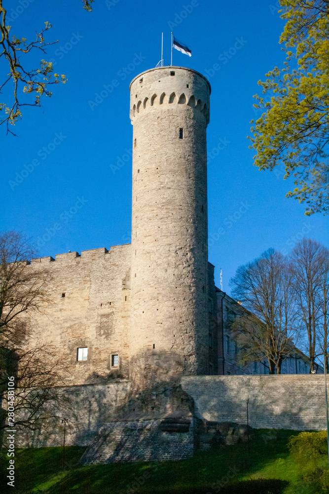 Tall Hermann tower and Parliament building. Toompea, Governors garden, Tallinn, Estonia with Estonian waiving flag on the blue sky