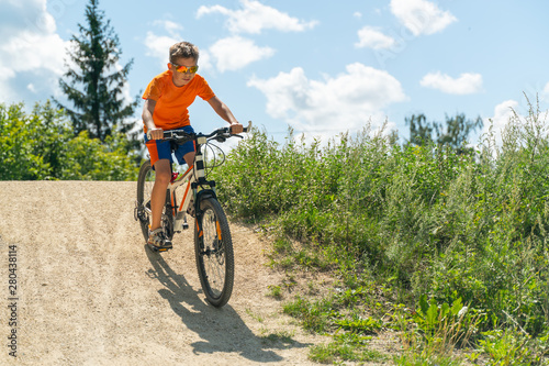 A boy on a mountain bike drives off a hill