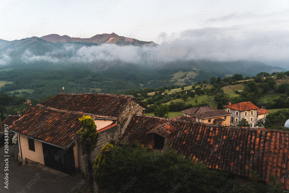 Landscape view of mountains above a small village during sunrise in Asturias, Spain. 