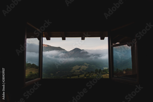 A cloudy  mountain sunrise viewed through a window in Asturias  Spain during summer. 