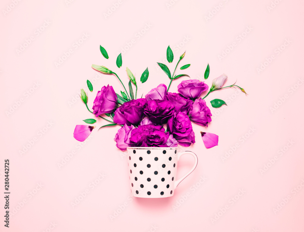Cup of coffee abd beautiful flowers on pink background.