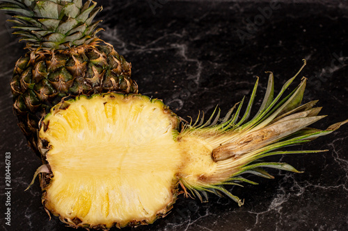 Ripe anas pineapple in a cut on a dark background.