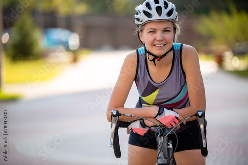 Image of young woman in helmet on bike ride on summer day