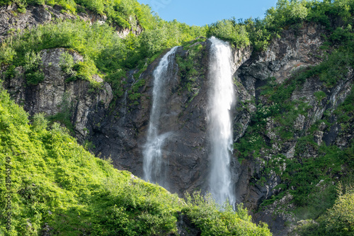 Views of the green mountains with the highest waterfall. Clear blue sky