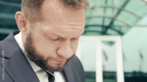 Close-up portrait of a tired business man muttering something