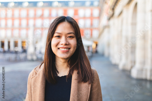 Spain, Madrid, portrait of smiling young woman at Plaza Mayor photo