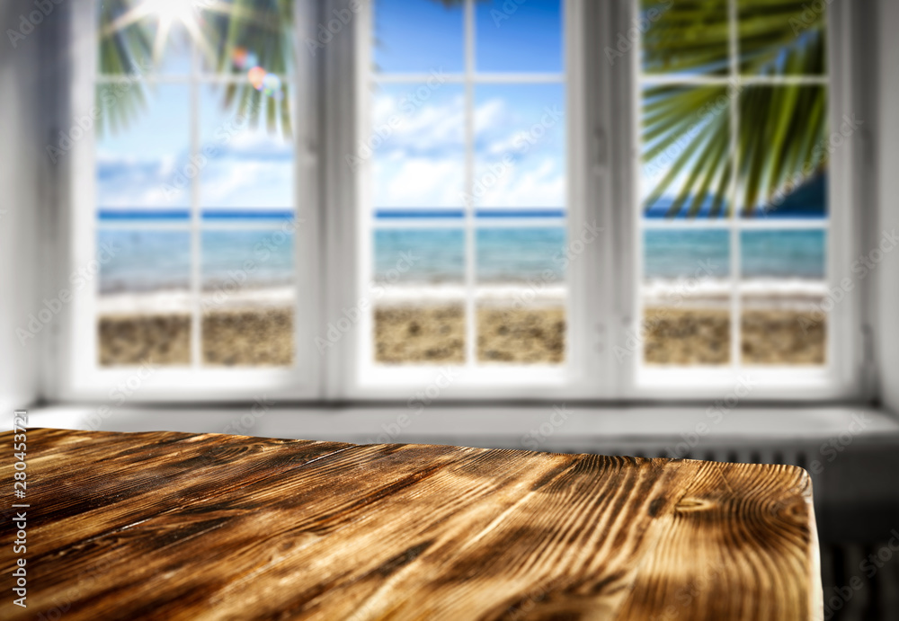 Window and table background with beautiful blue ocean and sandy beach view behind the window. Summer sunny day. Empty space for your decoration and advertising product.