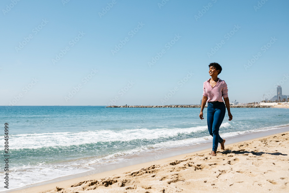 Woman walking on the beach, enjoying the sun after work Woman walking on the beach, enjoying the sun after work