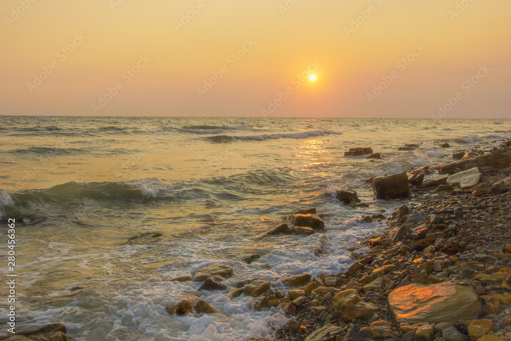 seascape sunset the sun sets the sea wave the sea foam. stones coast