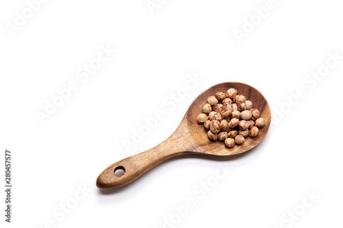 Cherry seeds in spoon on white background.