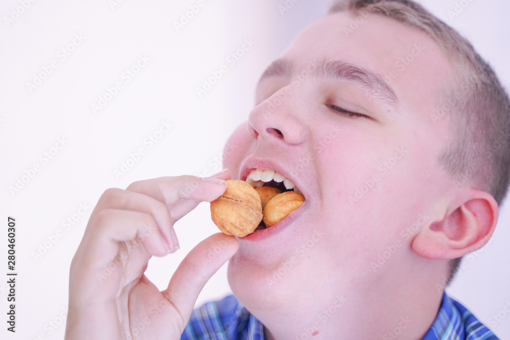 cute hungry teenager boy with fresh small bake sweets on white room background alone cute hungry teenager boy with fresh small bake sweets on white room background alone