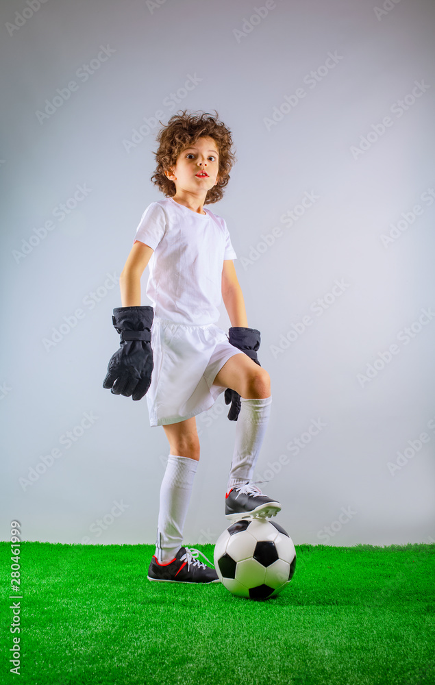 Kids - soccer champion. Boy goalkeeper in football sportswear on stadium with ball. Sport concept.