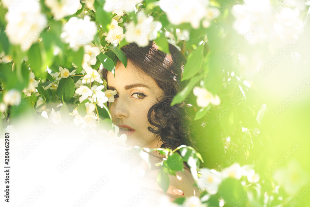 the girl stands among the Jasmine bushes and inhales the fragrance of flowers the girl stands among the Jasmine bushes and inhales the fragrance of flowers