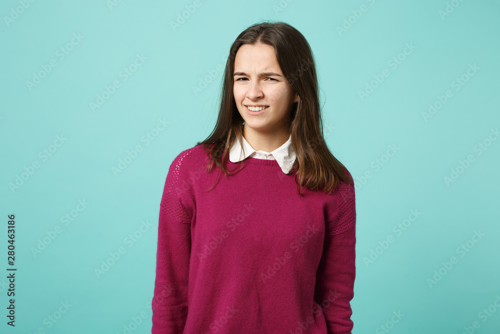 Fototapeta premium Young fun sad upset perplexed disturb brunette woman girl in red casual clothes posing isolated on blue wall background studio portrait. People sincere emotions lifestyle concept. Mock up copy space.