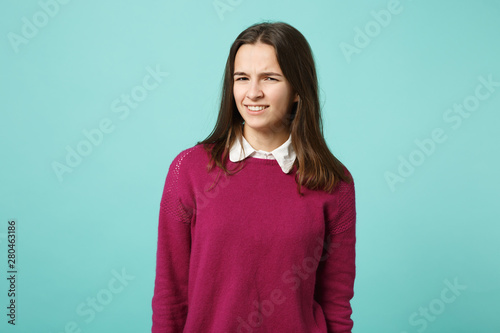 Young fun sad upset perplexed disturb brunette woman girl in red casual clothes posing isolated on blue wall background studio portrait. People sincere emotions lifestyle concept. Mock up copy space.