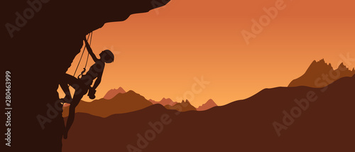 Valokuva Black silhouette of a climber on a cliff with mountains as a background