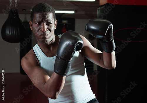 Potrait of african american boxer who is training in gym © JackF