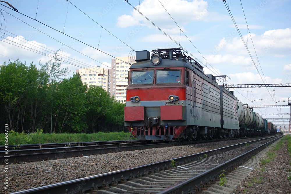 Electric train with a train in Russia. Summer day