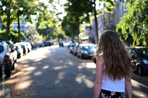 Canvas Print Handsome young woman with beautiful long hair standing in the street where she l