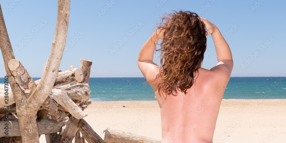 Rear view of naked woman standing on beach looking sea in web banner template header Stock Photo Adobe Stock image