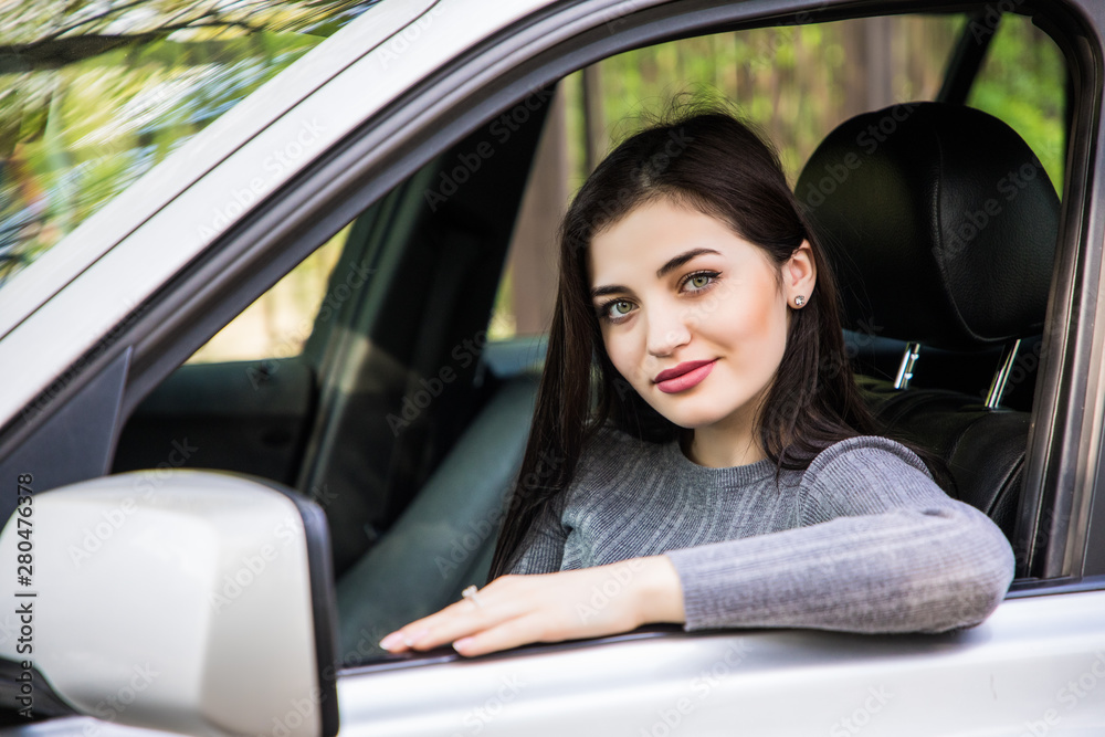 Smiling woman sitting in car looking from window