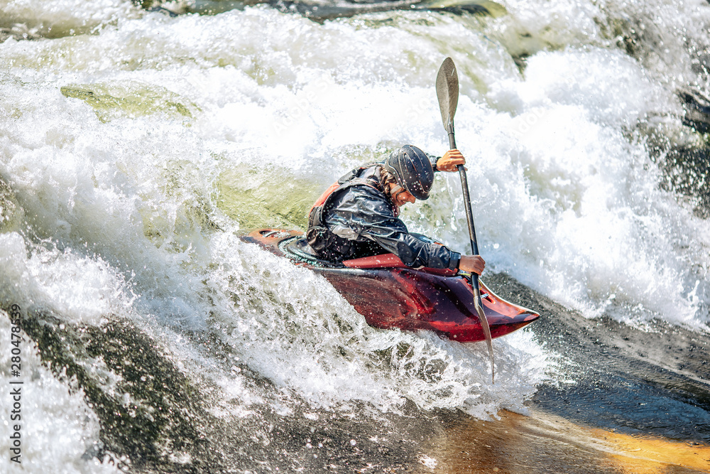 Whitewater kayaking, extreme sport rafting. Guy in kayak sails mountain river