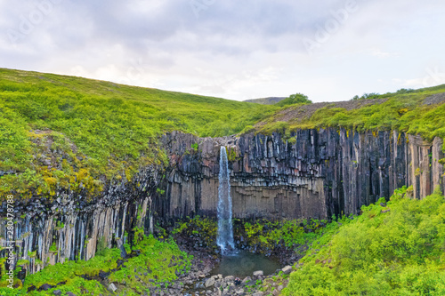 Beautiful summer landscape of Iceland. High thin waterfall.